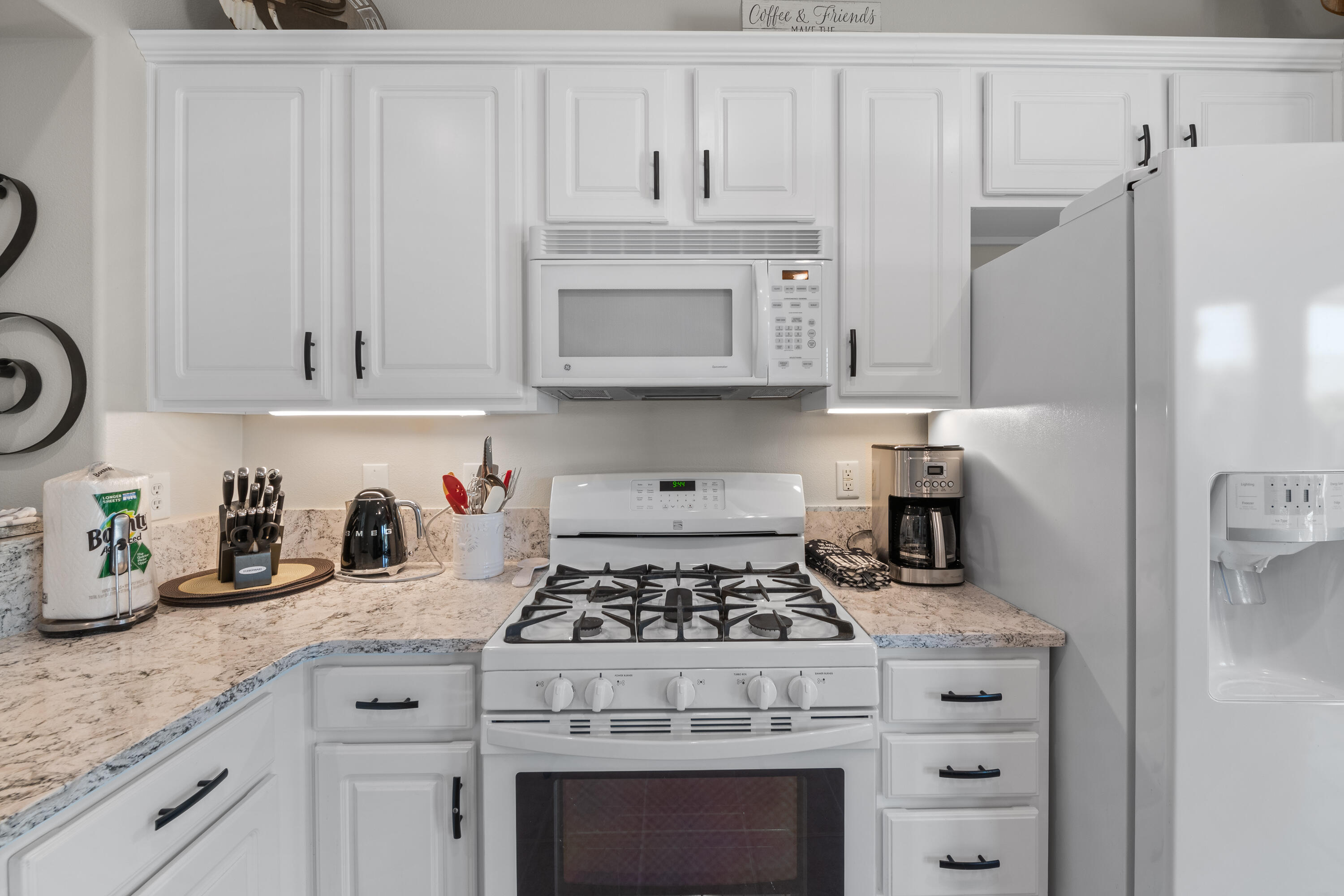 78680 Postbridge Circle Palm Desert, CA 92211 - Photo 14 of 54 a kitchen with granite countertop white cabinets and stainless steel appliances