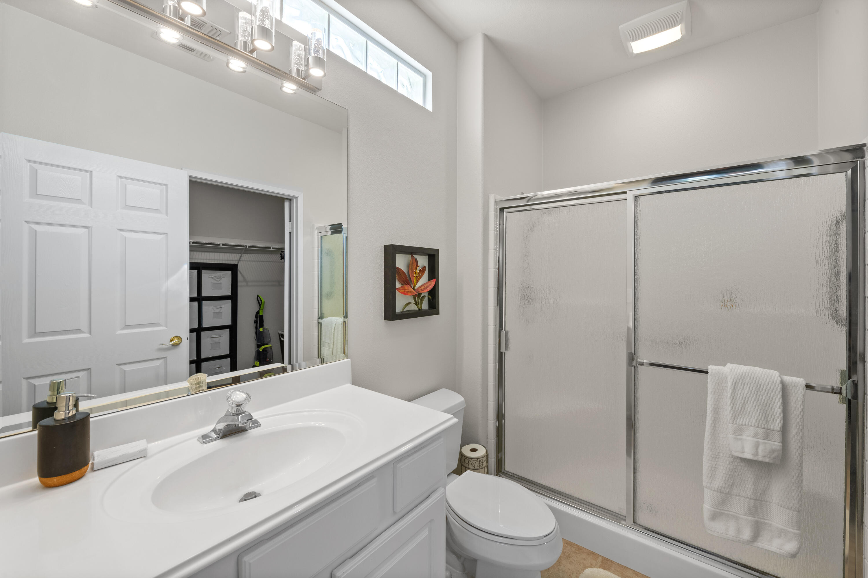78680 Postbridge Circle Palm Desert, CA 92211 - Photo 18 of 54 a bathroom with a sink a mirror a toilet and shower