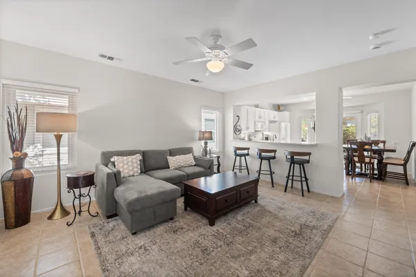 a living room with furniture and a dining table with kitchen view
