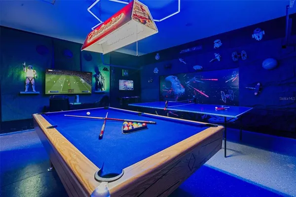 a room with pool table and chairs