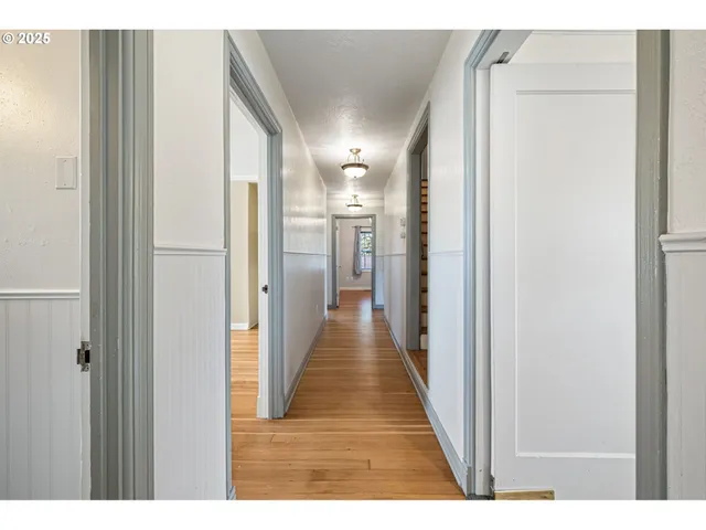 a view of a hallway with wooden floor