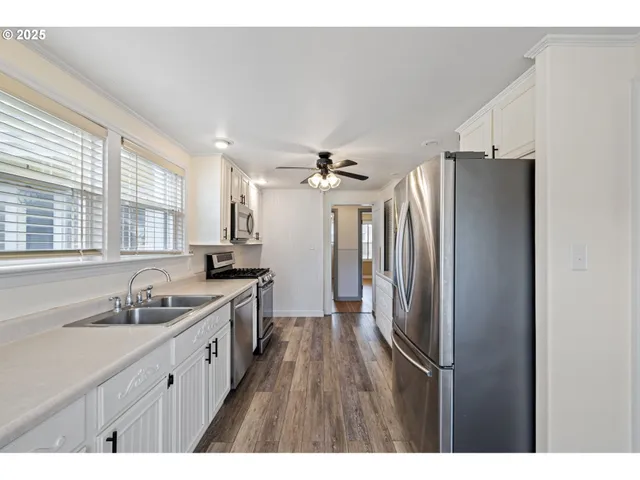 a kitchen with kitchen island a sink stainless steel appliances and cabinets