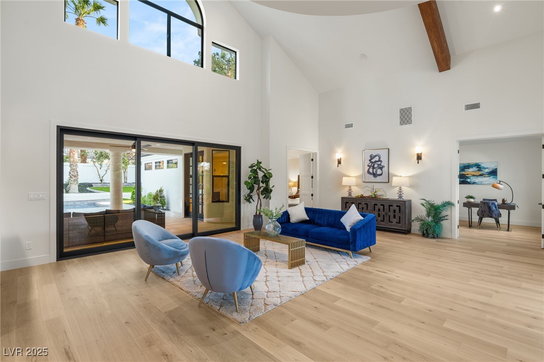 2316 Prometheus Court Henderson, NV 89074 - Photo 6 of 92 Living area featuring high vaulted ceiling, visible vents, baseboards, and wood finished floors