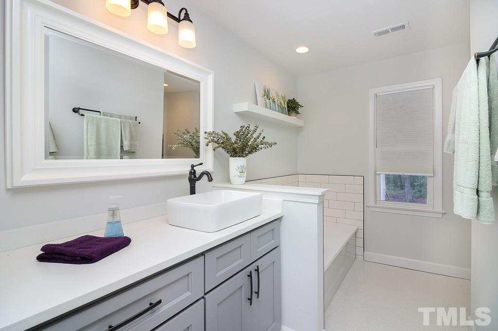 10025 Sycamore Road Raleigh, NC 27613 - Photo 22 of 30 a bathroom with a sink and a mirror