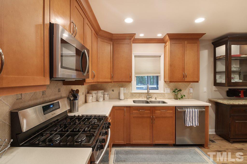 10025 Sycamore Road Raleigh, NC 27613 - Photo 8 of 30 a kitchen with a sink a stove and cabinets