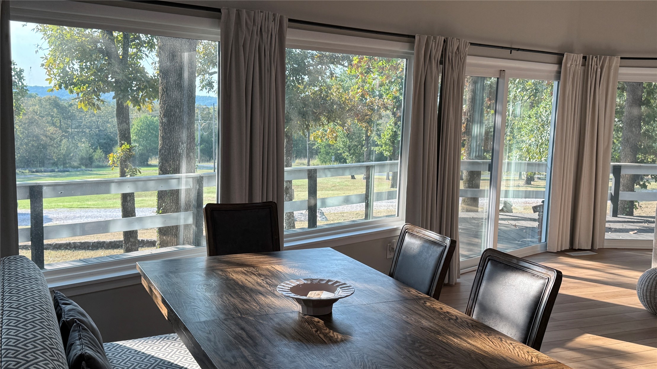 96358 South 4531 Road Vian, OK 74962 - Photo 7 of 58 Expansive windows offering abundant natural illumination, sliding glass door access to the exterior, wood-finish flooring, and a substantial wood dining surface