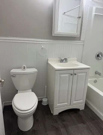 a bathroom with a toilet sink and mirror