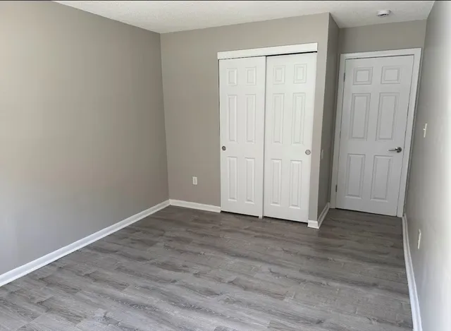 a view of an empty room with wooden floor