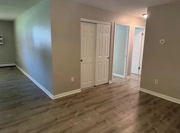 a view of an empty room with wooden floor