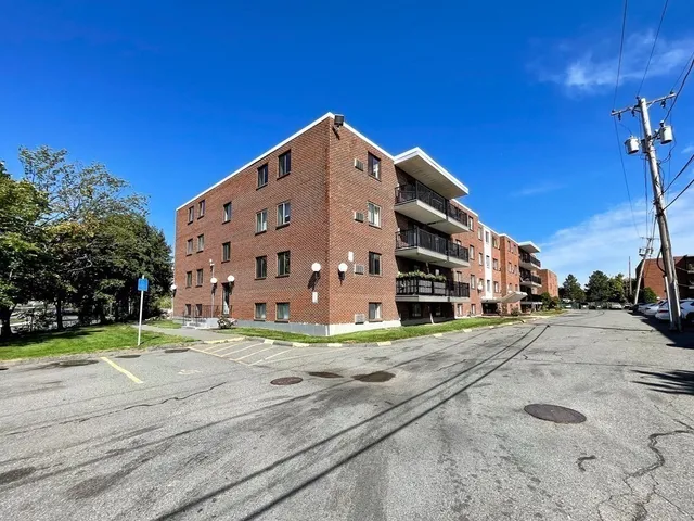 a large building with a small yard and large trees