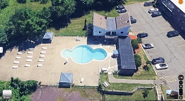 an aerial view of residential houses with outdoor space and parking