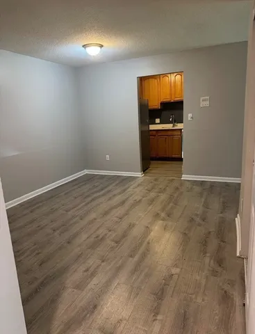 a view of empty room with wooden floor and windows