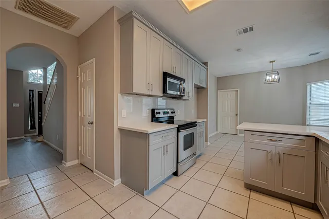 a kitchen with granite countertop white cabinets and stainless steel appliances