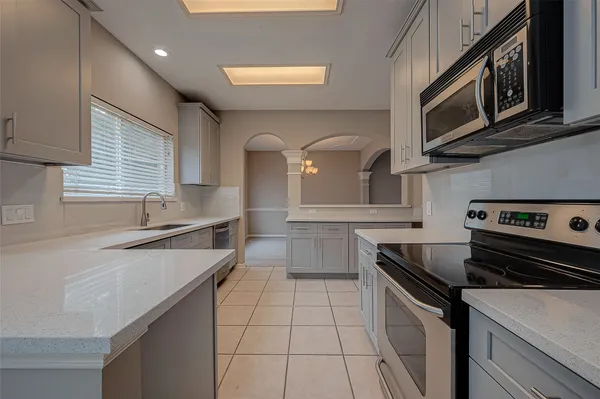 a kitchen with stainless steel appliances a sink a stove and cabinets