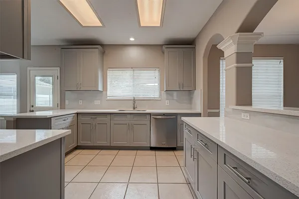 a kitchen with a sink window and cabinets