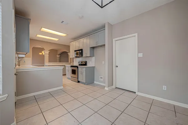 a kitchen with white cabinets and appliances