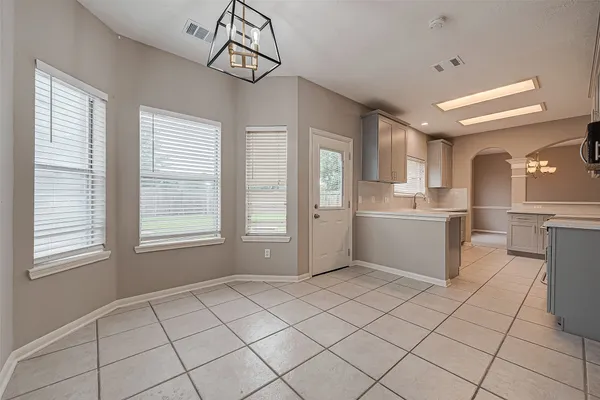 a kitchen with a white cabinets and window