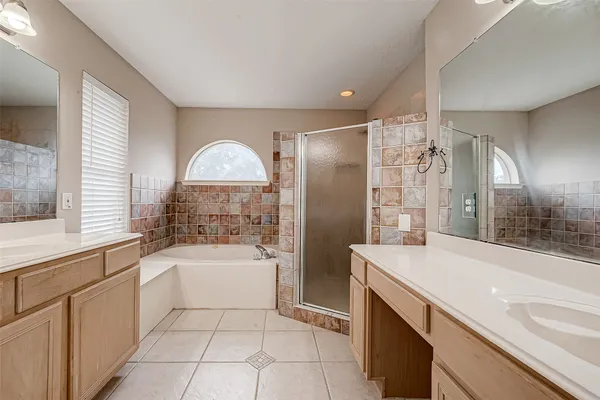 a spacious bathroom with a bathtub shower sink and mirror