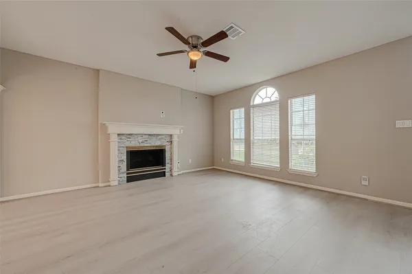 a view of an empty room with a fireplace and a window