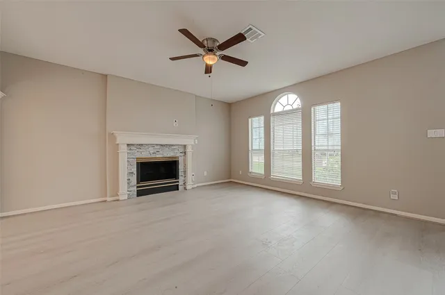 a view of an empty room with a fireplace and a window