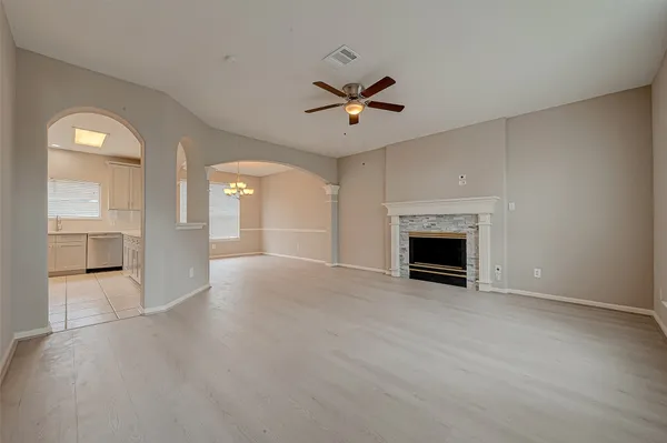 an empty room with windows and fireplace