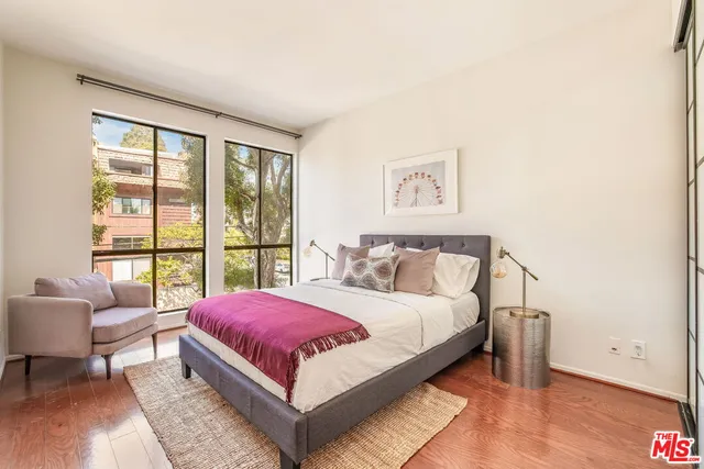 a bedroom with a bed and a large window