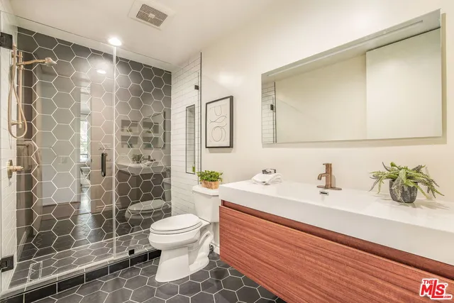 a bathroom with a sink a toilet and shower