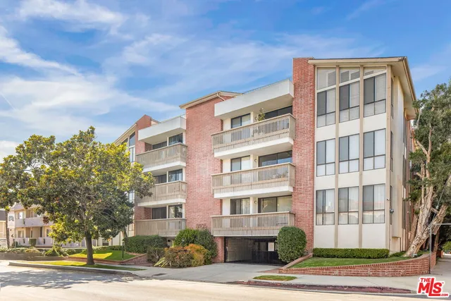 a front view of a residential apartment building with a yard