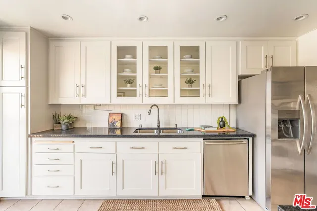 a kitchen with granite countertop a sink stainless steel appliances and cabinets