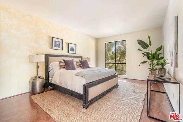 a bedroom with a large bed and a potted plant