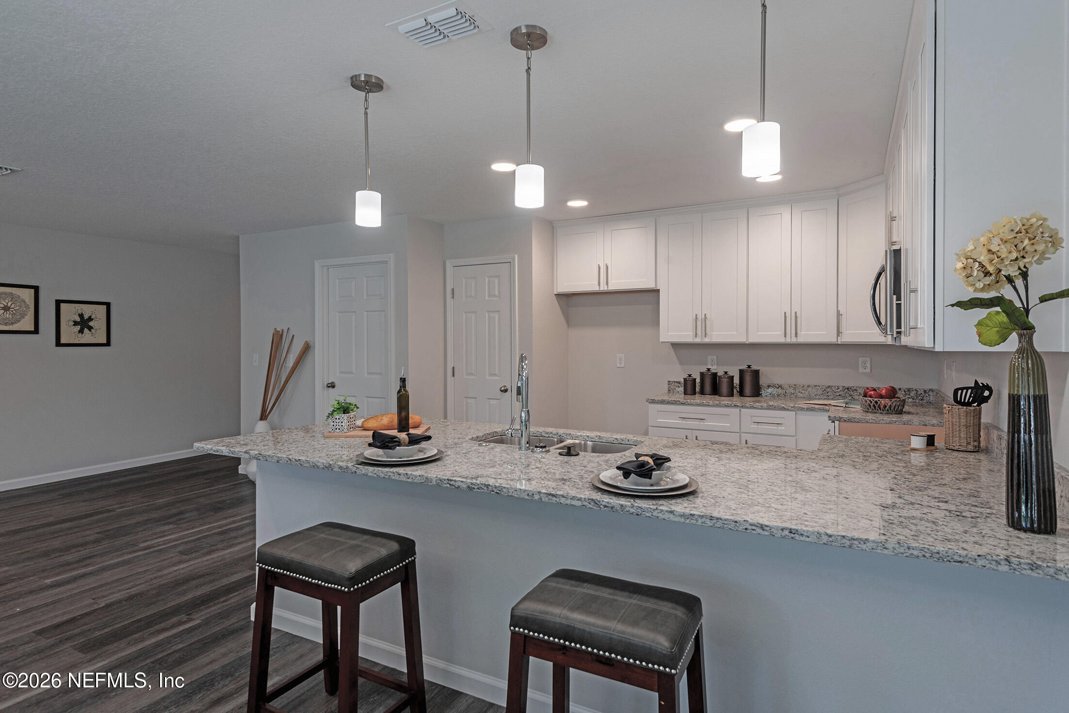 451 Cahoon Road North Jacksonville, FL 32220 - Photo 17 of 33 a kitchen with a sink a stove and chairs with wooden floor