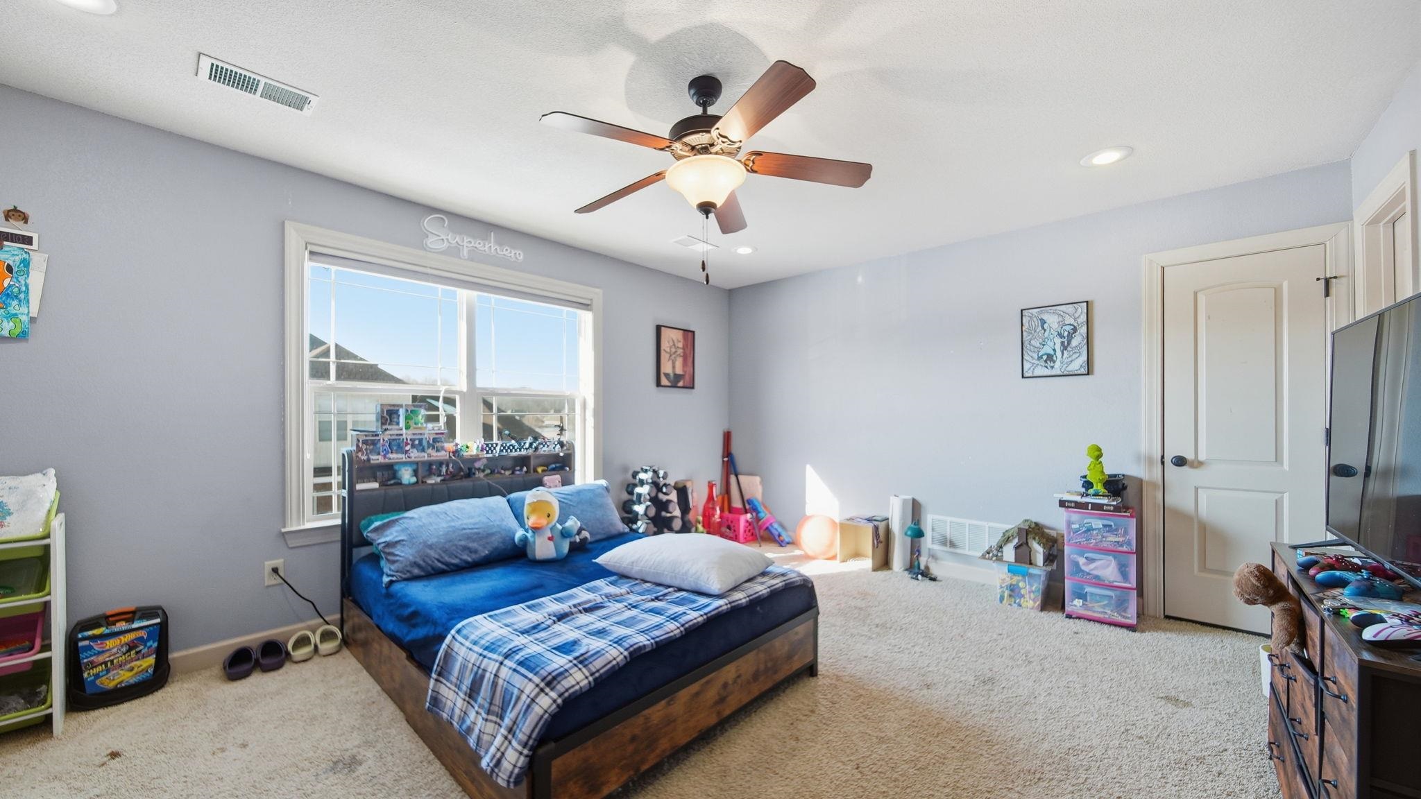 34 Carson Cove Atoka, TN 38004 - Photo 23 of 27 a bedroom with a bed and a chandelier