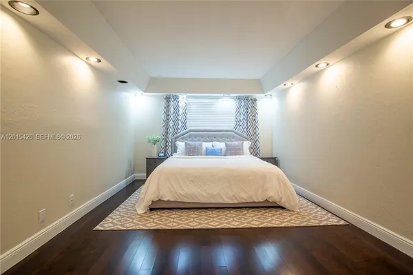 a large bed sitting in a bedroom next to a window
