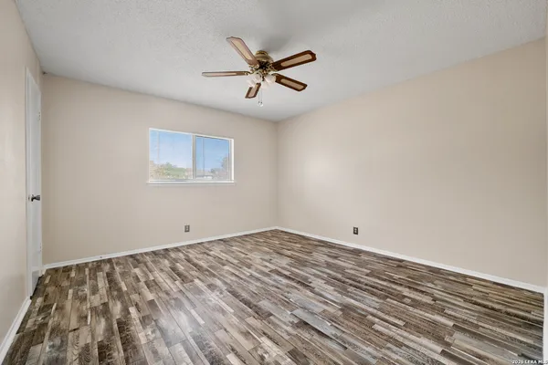 a view of empty room with wooden floor