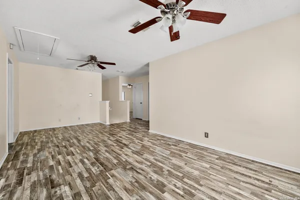 an empty room with a window and a fan