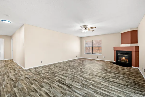 a view of empty room with fan and fireplace