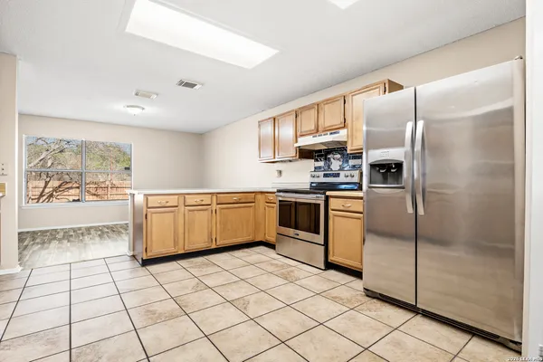 a kitchen with stainless steel appliances a refrigerator sink and microwave