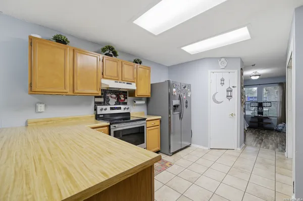 a kitchen with a sink a refrigerator and cabinets