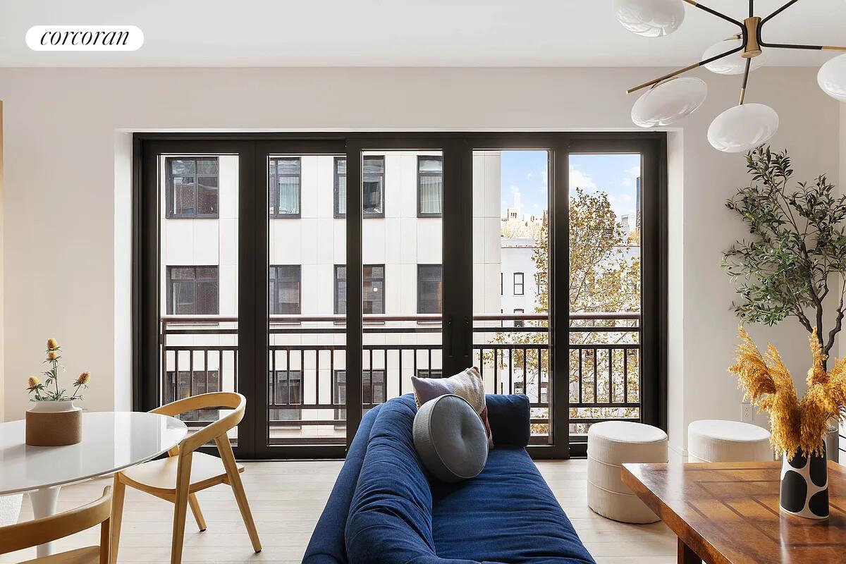 428 West 19th Street, Unit 4D Manhattan, NY 10011 - Photo 4 of 15 a living room with furniture and a large window