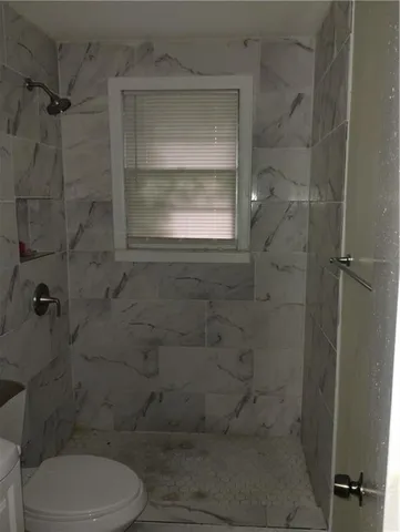 a bathroom with a toilet and a shower