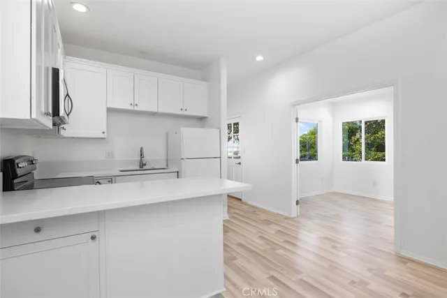 a kitchen with a sink a window and cabinets