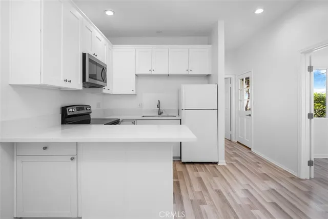 a kitchen with stainless steel appliances a refrigerator a sink a stove a microwave and cabinets