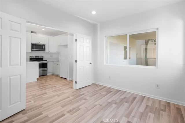 a view of a kitchen with wooden floor and a window