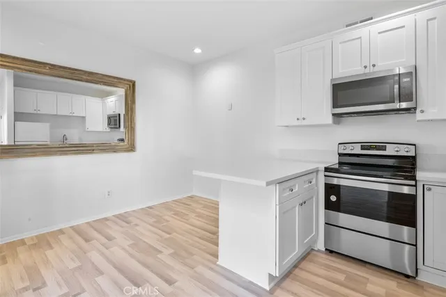 a kitchen with white cabinets and stainless steel appliances