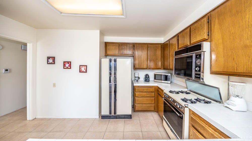 3540 Vista Glen Circle Yorba Linda, CA 92886 - Photo 19 of 31 a kitchen with a refrigerator a stove top oven and cabinets
