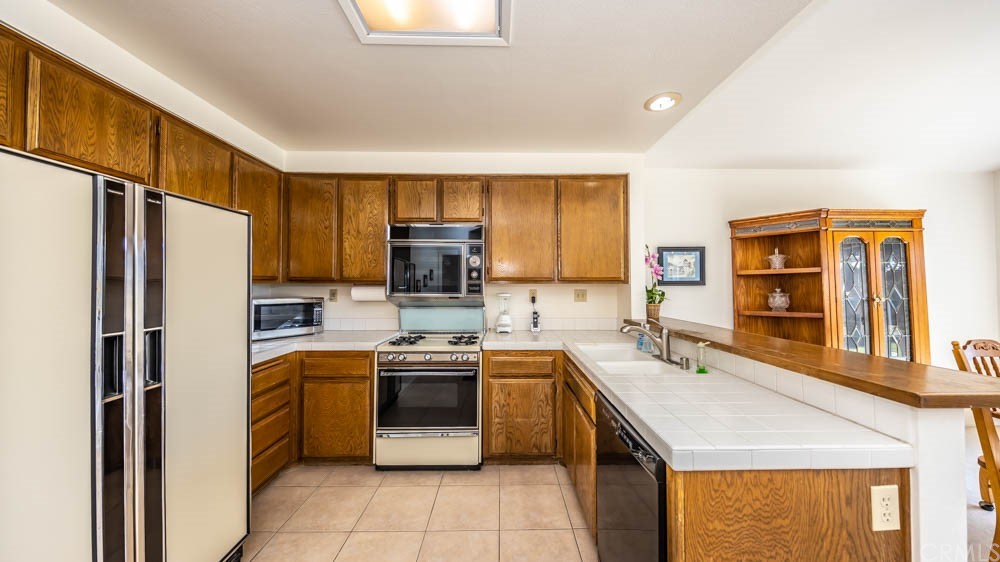 3540 Vista Glen Circle Yorba Linda, CA 92886 - Photo 4 of 31 a kitchen with stainless steel appliances granite countertop a sink stove refrigerator and window