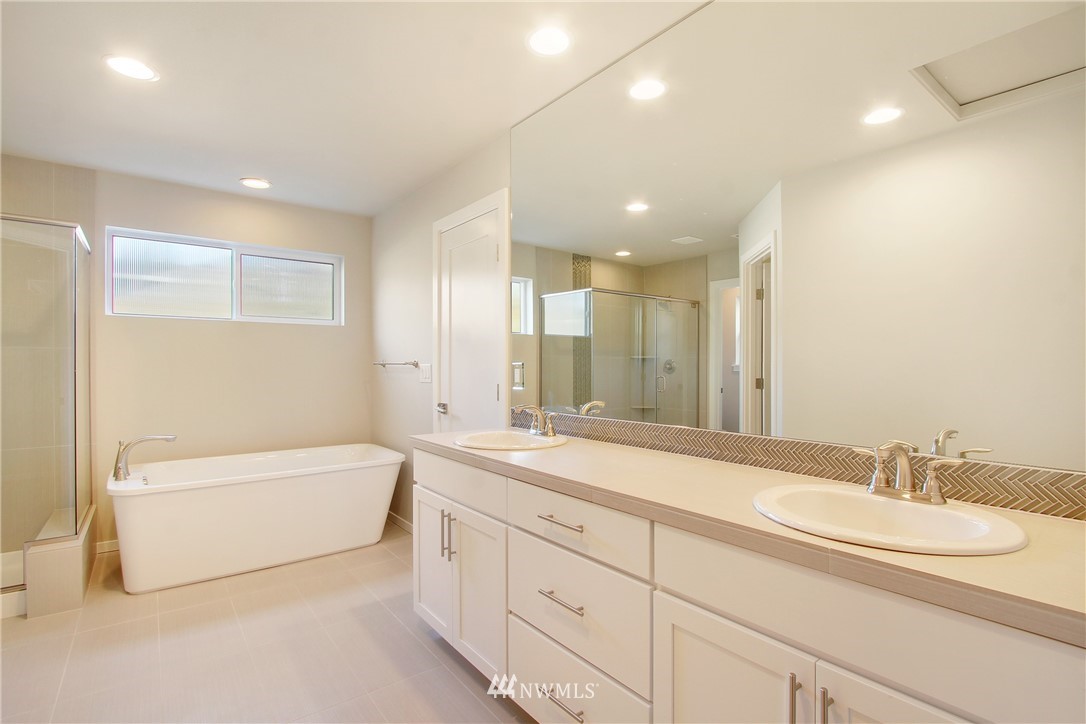 210 180th Place Southwest, Unit CT 01 Bothell, WA 98012 - Photo 12 of 19 a bathroom with a double vanity sink a mirror and a bathtub