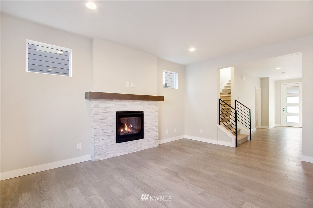 210 180th Place Southwest, Unit CT 01 Bothell, WA 98012 - Photo 3 of 19 a view of a livingroom with wooden floor and a fireplace
