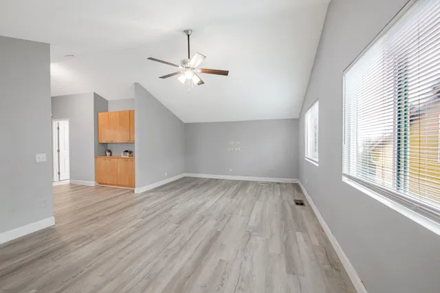 an empty room with a window and a ceiling fan