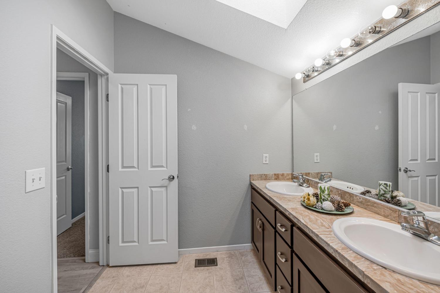 9065 Robbins Road Sacramento, CA 95829 - Photo 32 of 45 a bathroom with a double vanity sink and a mirror